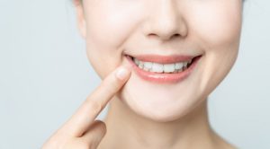 a woman pointing at her teeth